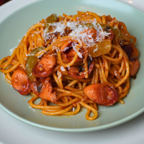 Japanische Ketchup Spaghetti auf grünem Teller mit Parmesankäse