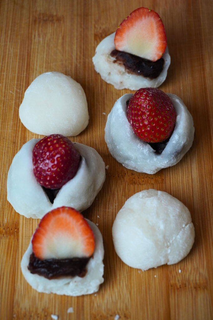 weißer mochi teig gefüllt mit erdbeeren und roter bohnen paste