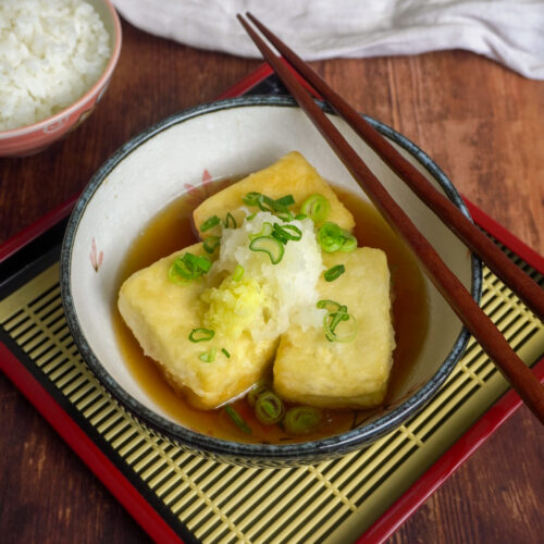 Knuspriger Agedashi Tofu in Dashi-Brühe, serviert mit Frühlingszwiebeln, Ingwer und Daikon-Rettich.