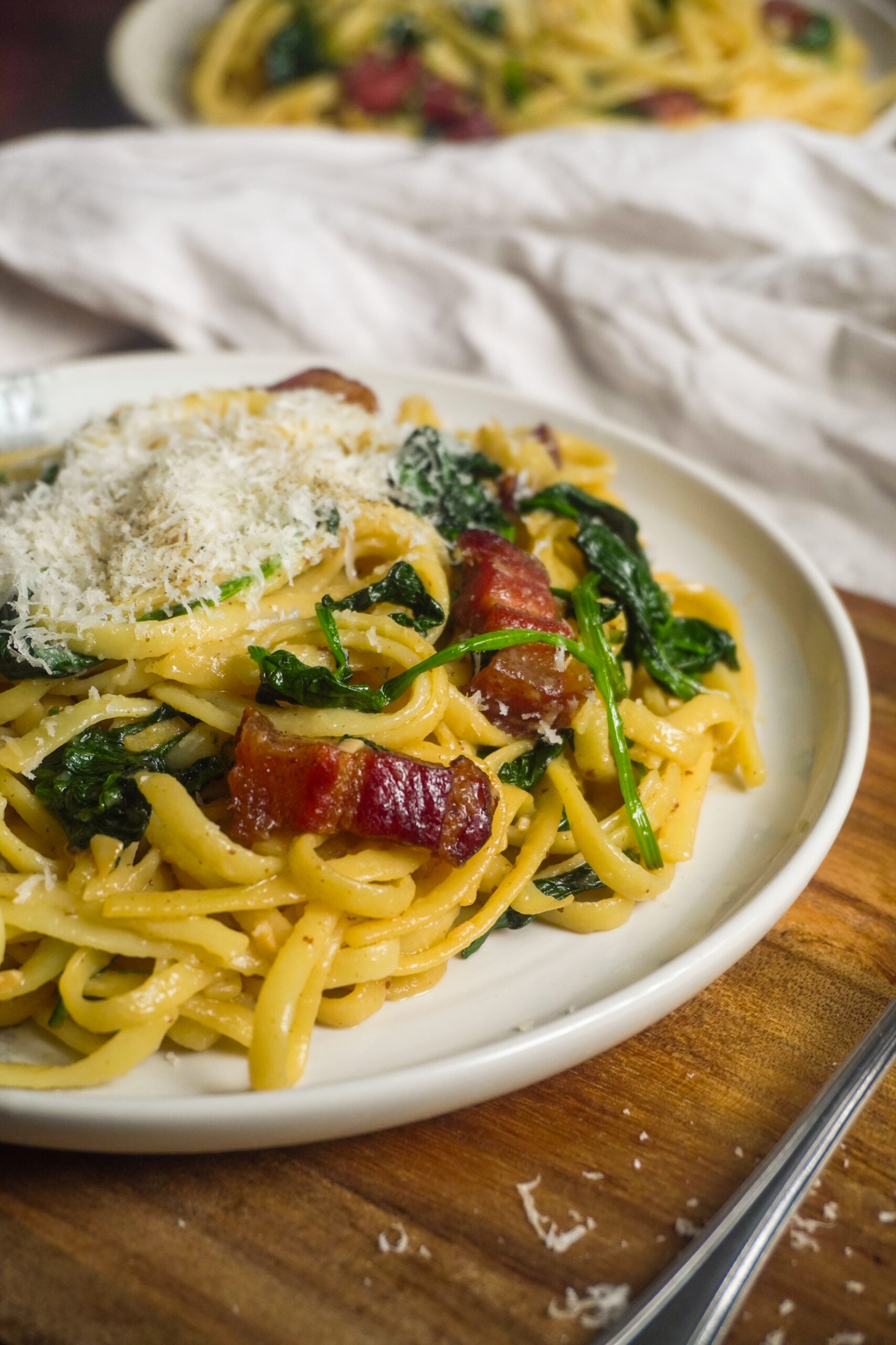 Japanische Wafu-Pasta mit Linguine, knusprigem Speck und frischem Spinat, serviert mit frisch geriebenem Parmesan. Diese einfache und aromatische Pasta wird mit Sojasauce, Dashi und Mirin verfeinert und ist eine beliebte Fusion aus japanischer und italienischer Küche.
