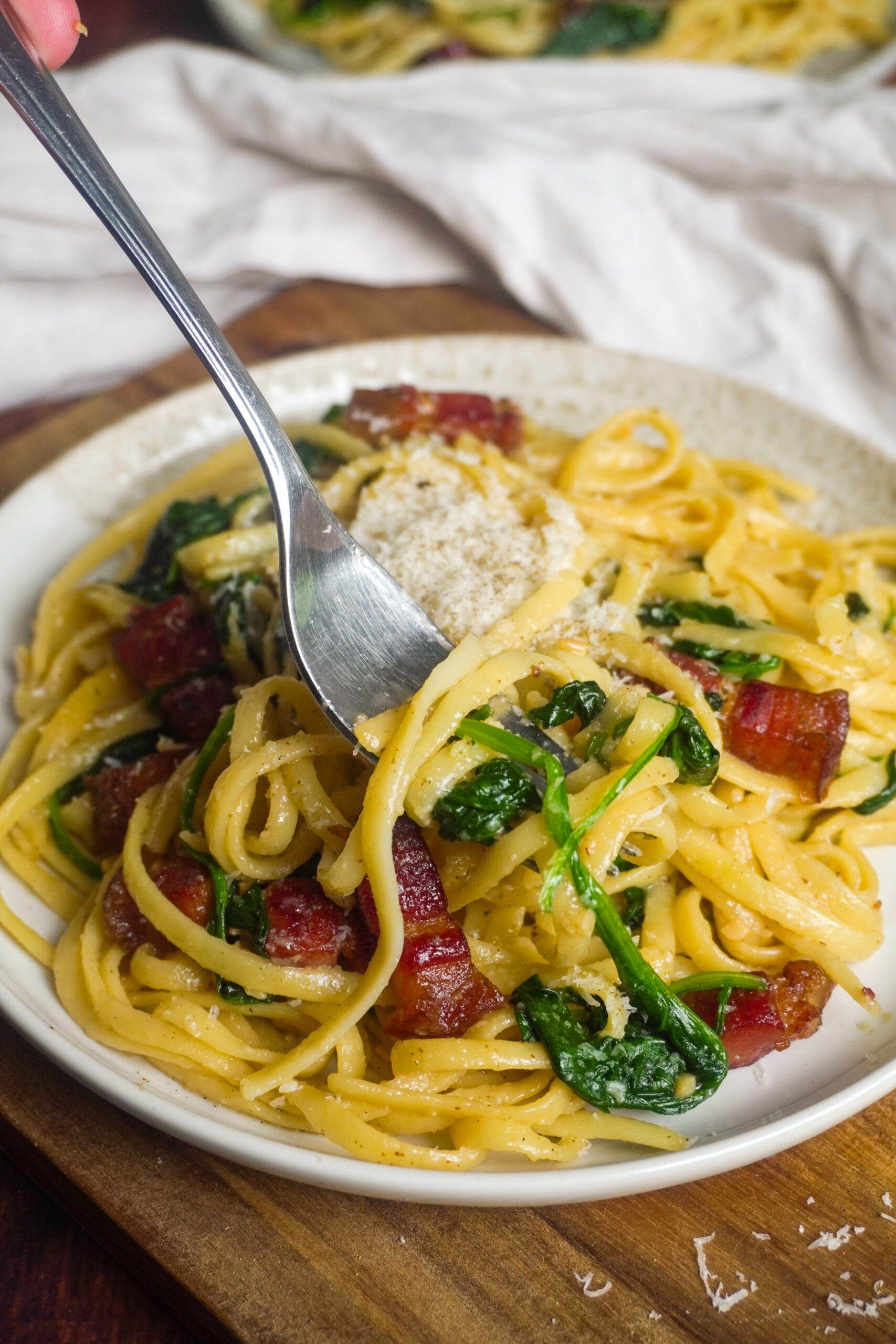 Japanische Wafu-Pasta mit Linguine, knusprigem Speck und frischem Spinat, serviert mit frisch geriebenem Parmesan. Diese einfache und aromatische Pasta wird mit Sojasauce, Dashi und Mirin verfeinert und ist eine beliebte Fusion aus japanischer und italienischer Küche.
