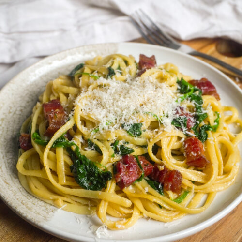 Japanische Wafu-Pasta mit Linguine, knusprigem Speck und frischem Spinat, serviert mit frisch geriebenem Parmesan. Diese einfache und aromatische Pasta wird mit Sojasauce, Dashi und Mirin verfeinert und ist eine beliebte Fusion aus japanischer und italienischer Küche.