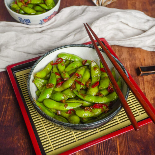 Edamame gewürzt mit Chili und Knoblauch in einer Schüssel.